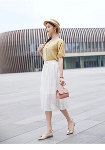 Tenue élégante avec chemise jaune, jupe en dentelle blanche et sac à main rose