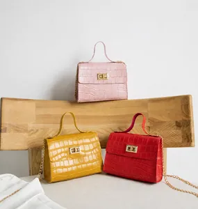 Détail de sacs à bandoulière motif crocodile en couleurs rose, jaune et rouge