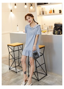 Detail of light blue short sleeve dress featuring white navy collar and ruffled hemline