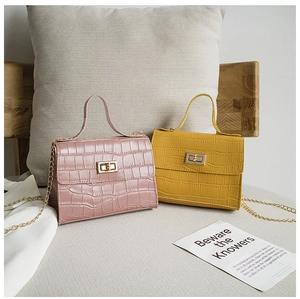 Détail de la texture crocodile sur les sacs à bandoulière rose et jaune
