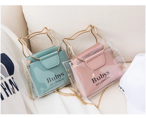 Close-up of clear PVC bags with gold cat-ear handles and elegant chain shoulder straps