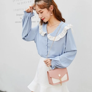 Cat ear crossbody bag with pearl tassel shown on a blue chiffon shirt and white skirt outfit