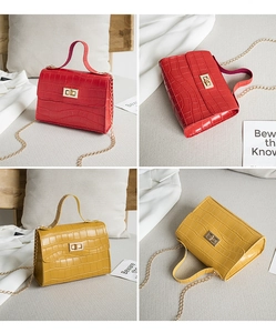 Détail macro de la texture crocodile sur mini sacs rouge et jaune avec fermoir