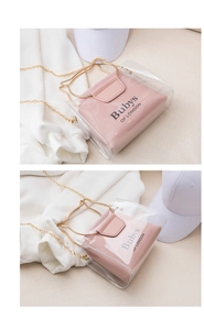 Detail of transparent PVC bucket bag featuring golden cat-shaped handle and pink inner pouch