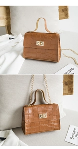 Détail de la texture crocodile marron et du fermoir rotatif en métal doré du sac