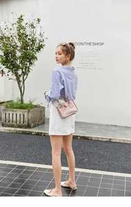Detailansicht der rosa transparenten PVC Tasche mit Goldkette an einem schicken Model