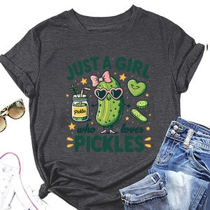 Flat lay of a grey pickle-themed t-shirt with sunglasses, denim shorts and sneakers