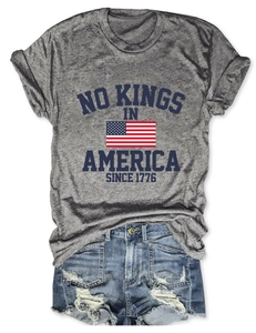 Détail du t-shirt gris No Kings in America et short en jean déchiré ensemble d'été