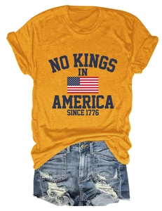 Détail de l'imprimé vintage 'No Kings in America' sur un t-shirt jaune moutarde à col rond