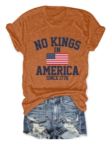 T-shirt orange à imprimé No Kings in America à plat avec un short en jean bleu
