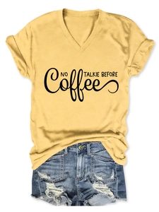 Detail of V-neck ginger yellow t-shirt with black NO TALKIE BEFORE text and denim shorts