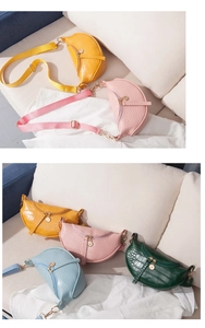 Close-up of crocodile pattern saddle bags in multiple colors with adjustable straps