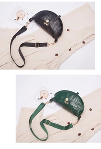 Detail of crocodile pattern saddle bag showing black and dark green PU texture and hardware