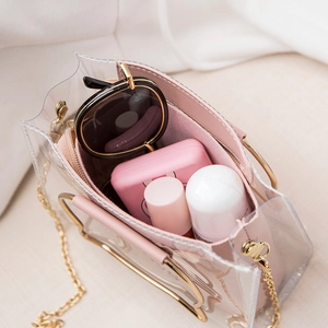 Transparent pink PVC bucket bag with gold handle and interior makeup accessories