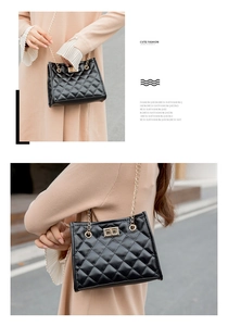 Close-up of quilted black crossbody bag with gold chain strap and turn-lock detail