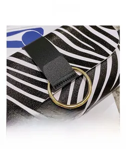 Detailed close-up of zebra pattern handbag with black leather strap and gold metal ring