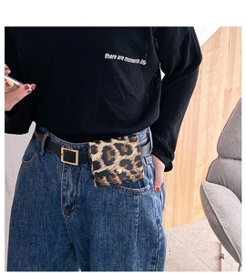 Detail of leopard print waist bag with metal buckle and slim black leather belt