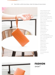 Detail of orange crocodile texture long wallet with wristlet and zipper closure
