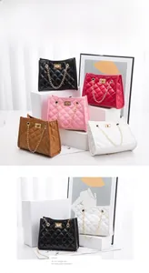 Quilted bucket bag detail showing metal chain handle and gold square twist-lock closure