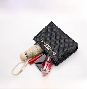 Spacious interior of a black quilted bucket bag holding a phone, umbrella, and cosmetics