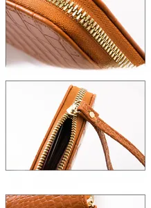 Detailed macro view of crocodile texture leather wallet with gold hardware and smooth zipper