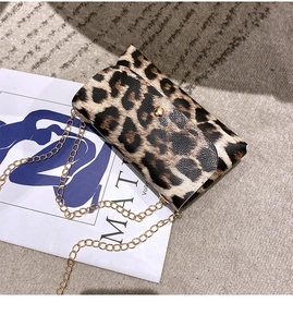 Detail of leopard print envelope bag with gold chain strap and circular metal lock