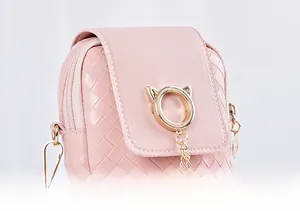 Detail of woven texture and golden cat-ear metal ring on pink mobile phone bag
