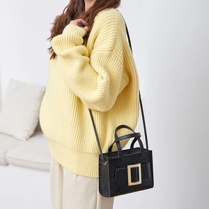 Chic yellow knit sweater paired with a black crocodile pattern mini handbag and gold buckle