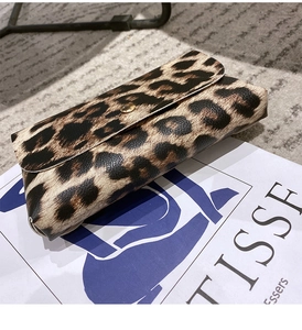 Close-up of animal print envelope bag featuring leopard pattern and gold round buckle