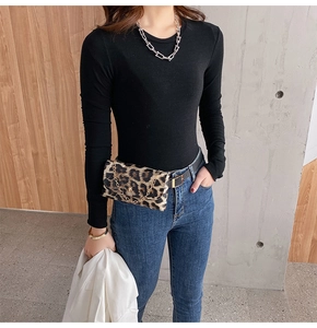 Close-up of leopard print waist bag with chain and leather belt on stylish model