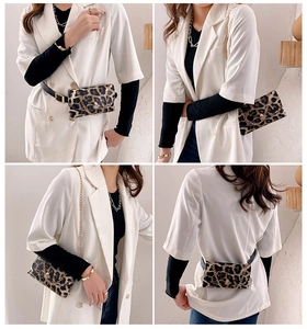 Detail showing versatile styling of leopard print crossbody bag with gold chain and belt