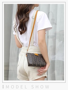 Close-up of a mini crossbody bag featuring dark brown floral patterns and yellow straps
