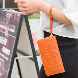 Vibrant orange crocodile pattern long clutch bag with wrist strap and zipper closure