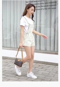Deep brown printed crossbody bag with yellow strap shown on casual style outfit