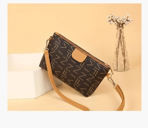 Detail view of stylish crossbody bag with letter print patterns and leather accents