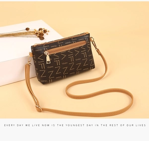 Detail of vintage brown monogram crossbody bag showing gold zipper and rear pocket texture
