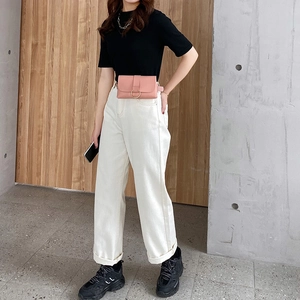 Pink leather waist bag with golden ring buckle worn on casual black and white outfit