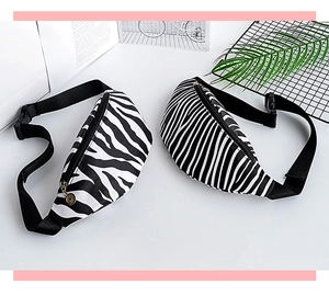 Top-down view of zebra print waist bags with adjustable straps and metal zippers