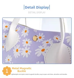 Detail van bloementas met gouden metalen magneetsluiting en wit madeliefjespatroon