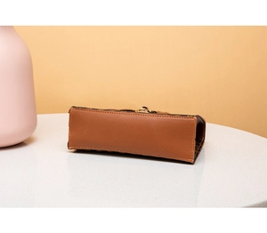 Detail shot of vintage patterned crossbody bag base with precise stitching and metal clasp
