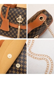 Detail view of the vintage floral handbag with gold crown tassel and metal chain strap