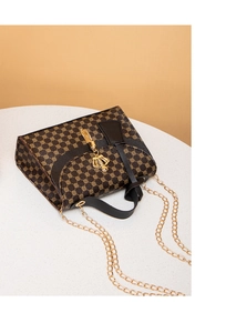 Detail of vintage crossbody bag with gold crown tassel and metal chain strap