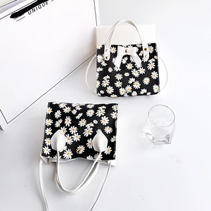 Petit sac à bandoulière noir avec imprimés marguerites et nœud décoratif blanc