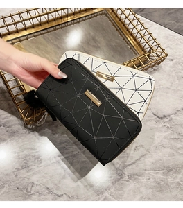 Macro detail of geometric quilted wallets in black and white with gold accents
