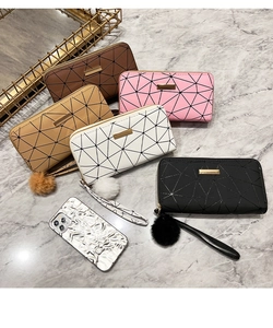 Detail showing five colors of quilted long wallets with wristlets and pompom charms