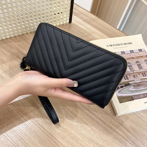 Elegant black long wallet for women featuring V-quilted pattern and fuzzy pompom charm