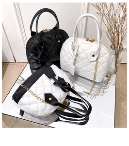 Trois sacs coquilles en noir, blanc et bicolore avec matelassage losange sur socles miroir
