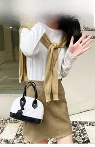 Détail du sac à main matelassé bicolore noir et blanc avec bandoulière chaîne dorée