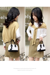 Détail d'un sac coquille contrasté noir et blanc avec chaîne dorée et motif matelassé