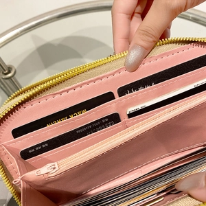 Pale pink long zipper wallet for women with multi-slot interior and gold hardware